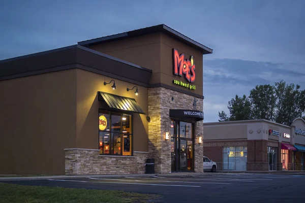 New Hartford, NY - 09 de septiembre de 2019: A Moe 's Southwest Grill Restaurant Lit at Night. Moe 's es un restaurante de comida casual rápida con más de 680 ubicaciones en 40 estados a partir de 2016 . — Foto de Stock