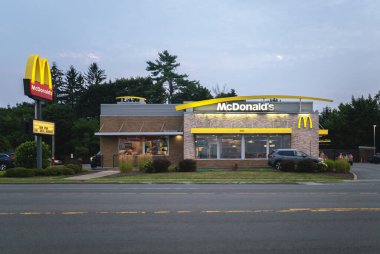 New Hartford, New York - 6 Ağustos 2025: 1940 'ta kurulan McDonald' s restoranının geniş akşam manzarası dünya çapında 39.000 'den fazla yeri bulunan dünyanın en büyük fast-food zincirlerinden biridir.