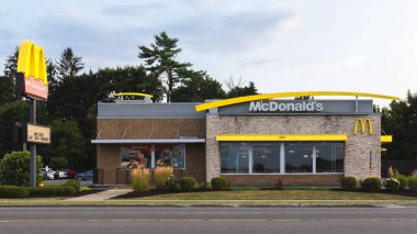 New Hartford, New York - 6 Ağustos 2025: 1940 'ta kurulan McDonald' s restoranının yakın çekim akşam manzarası dünya çapında 39.000 'den fazla yeri bulunan dünyanın en büyük fast-food zincirlerinden biridir.