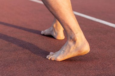 Koşu bandında ayakkabısız bir sporcunun bacakları. Sağlıklı yaşam tarzı kavramı.