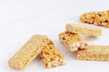 Beyaz ahşap arka planda yer fıstığı ve susam şekeri. Chikki - geleneksel Hint tatlısı. Boşluğu kopyala