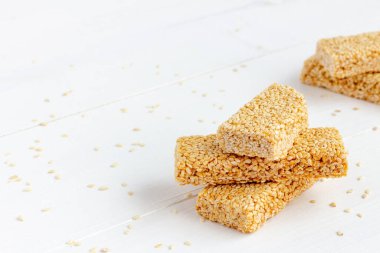 Chikki - geleneksel Hint tatlısı. Beyaz ahşap arka planda susam gevreği. Boşluğu kopyala
