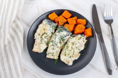 Soslu somon filetosu ve siyah tabakta balkabağı. Sağlıklı gıda konsepti.