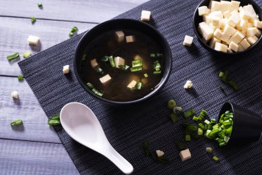 Japon sıcak miso çorbası, ahşap masada siyah bir kase içinde. Yukarıdan yatay görünüm