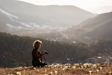 Turist fotoğrafçı kadın profesyonel kamerayla fotoğraf çekiyor. Macera seyahatleri, dağlar....