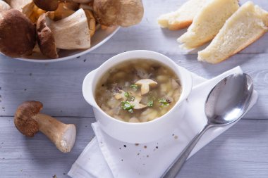 Porcini mantarlı mantar çorbası tabağı. Köy dokusunda taze maydanoz ve biber.