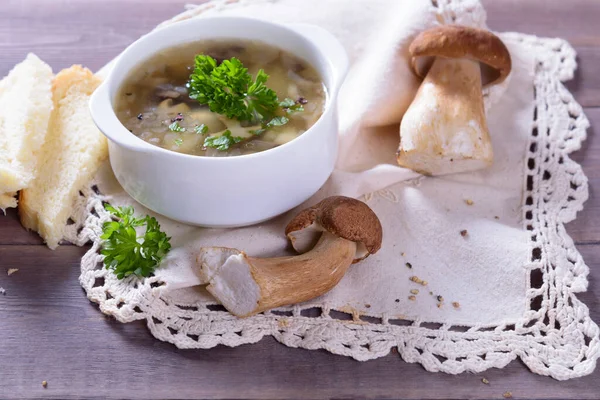Porcini mantarlı mantar çorbası tabağı. Köy dokusunda taze maydanoz ve biber.