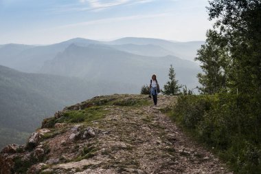 Kız dağ yoluna tırmandı. Güzel yaz manzarası