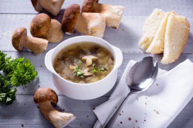 Porcini mantarlı mantar çorbası tabağı. Köy dokusunda taze maydanoz ve biber.