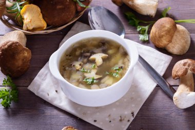 Porcini mantarlı mantar çorbası tabağı. Köy dokusunda taze maydanoz ve biber.