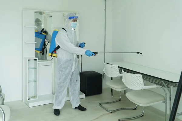 İşçiler koruyucu giysiler giyer ve maske takarlar. Binanın içini temizlemek için dezenfektan püskürtüyorum. Koronavirüsün yayılmasından sonra temizlikçiler popüler olmaya başladı.