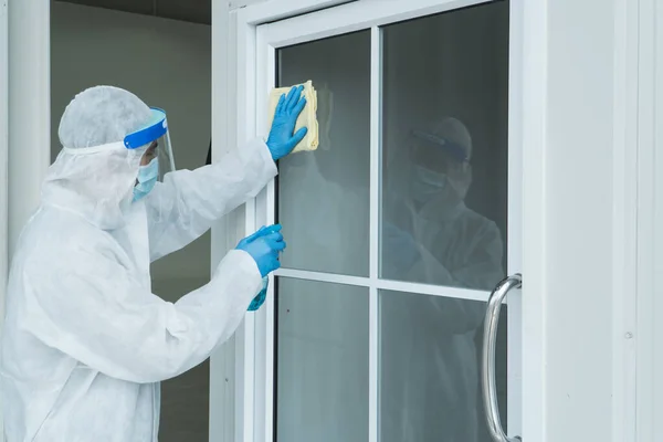 工人们穿着防护服 戴着面具 喷洒消毒剂用于大楼内的清洁 清洁服务专业人员在大脑皮层病毒扩散后变得流行 — 图库照片