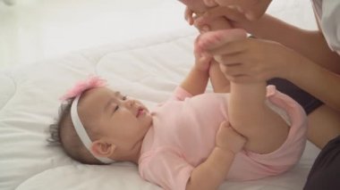 Yakın plan Mutlu Asyalı genç anne kızıyla oynuyor ve yatak odasında nazik ve şefkatli bir öpücük veriyor. Anne olmayı, ebeveynliği, aile hayatını ve çocuk bakımını göz önünde bulundurun..