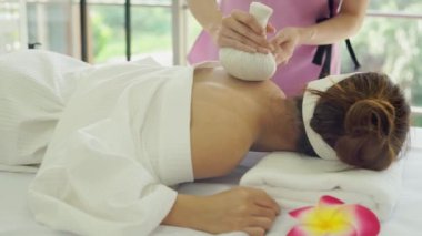 Genç Asyalı kadın güzellik salonunda yatakta uyuyor. Genç kadının omuz ve sırtında el masajı terapisti. Konsept spa, masaj, aromaterapi ve cilt bakımı..