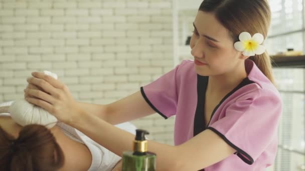 若いアジアの女性はスパの美容室でベッドで寝ています 若い女性の肩と背中に手マッサージセラピスト コンセプト女性のためのスパ マッサージ アロマセラピー スキンケア — ストック動画