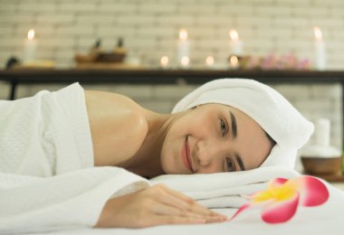 Güzel bir Asyalı kadın spa salonunda uzanıyor ve yatakta dinleniyor. Doğal otlar ve kadınlar için kaplıca geleneksel masaj konsepti.