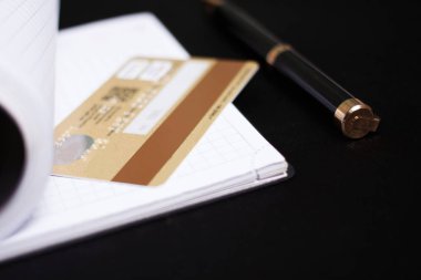 Not defteri, kalem ve kredi kartı.