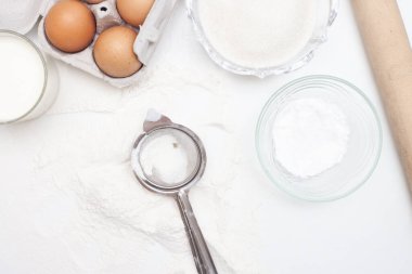 Fırın malzemeleri: un, yumurta, şeker, tereyağı, süt ve baharatlar gri mermer arka planda