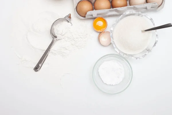 Baking ingredients: flour, eggs, sugar, butter, milk and spices on gray marble background