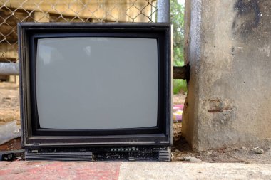 Yol üzerinde eski ve modası geçmiş eski bir televizyon..