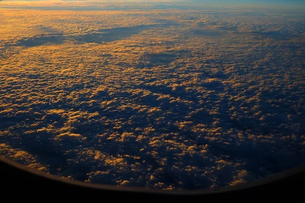 飛行機の窓からの日の出と雲のトップビュー — ストック写真