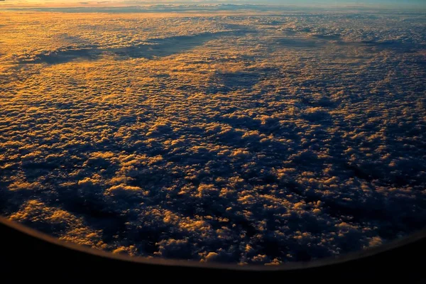 飛行機の窓からの日の出と雲のトップビュー — ストック写真