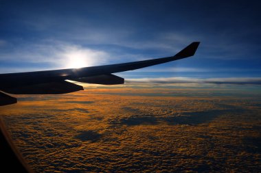 Uçak Penceresinden Gün Doğumu ile Bulutların Üst Görünümü.