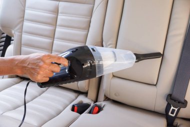 Elektrikli süpürge kullanarak araba temizlemek.