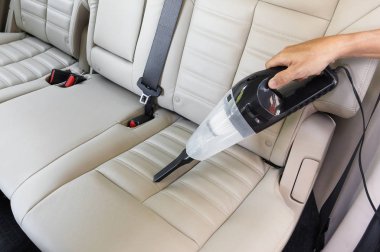 Elektrikli süpürge kullanarak araba temizlemek.