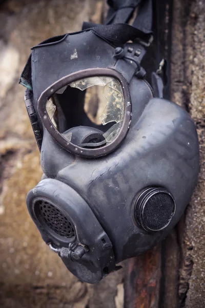 Broken gas mask hung on the wall / Toxic chemical weapon concept