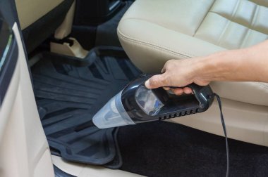 Elektrikli süpürge kullanarak araba temizlemek.