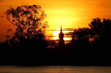 Günbatımı arkasında bir Buda heykeli                               