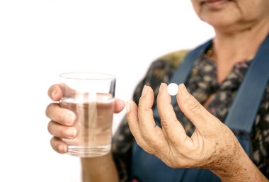 Kadın yaşlı beyaz bir ilaç tutan el