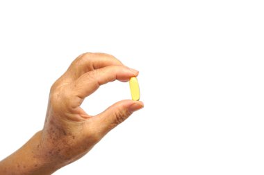Yaşlı kadın el beyaz izole bir balık yağı vitamin tablet tutarak                              