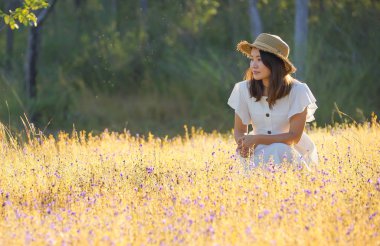 A girl in a beautiful grass flower field at Soi Sawan waterfall, Ubon Ratchathani, Thailand clipart