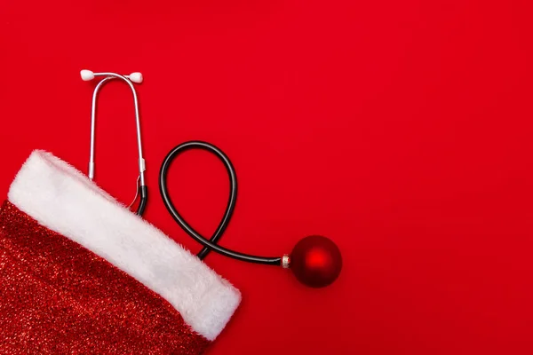 Medical Christmas banner with stethoscope on red background.