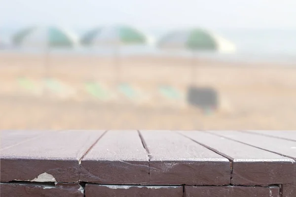 Dřevo stolu na rozostření pozadí beach. — Stock fotografie