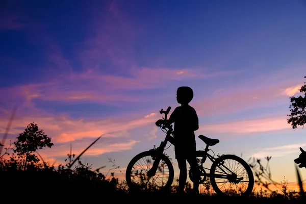 在日落时的小男孩骑自行车 — 图库照片