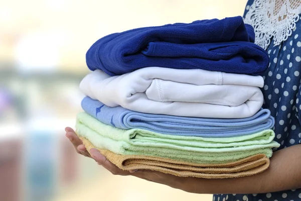 Woman hold clothes pile