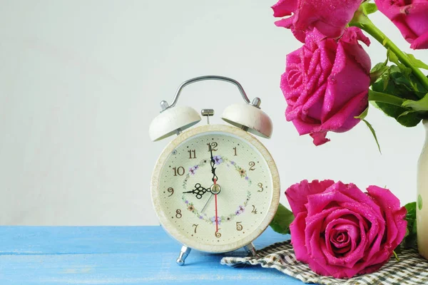 Natureza morta com despertador e rosa na mesa de madeira sobre grunge — Fotografia de Stock