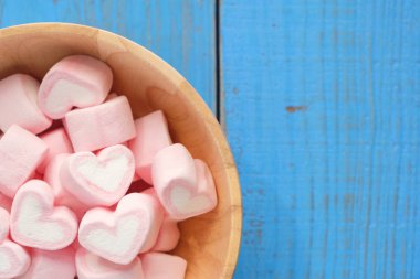 Arka planda pembe kalp şeklinde lokum var.