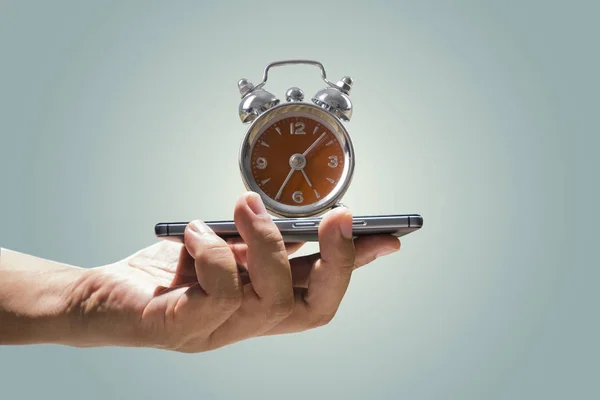 Akıllı telefondaki çalar saat. El ele tutuşan akıllı telefon.