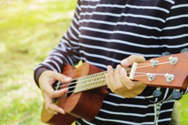 Genç kadın ukulele üzerinde oynama