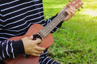 Genç kadın ukulele üzerinde oynama