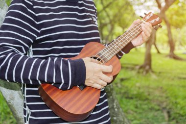 Genç kadın ukulele üzerinde oynama