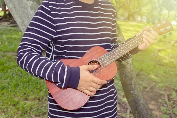 Genç kadın ukulele üzerinde oynama — Stok fotoğraf