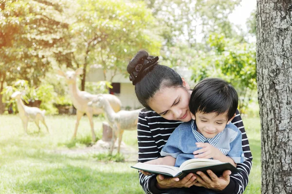 Madre enseña a los niños a leer libros . — Foto de Stock