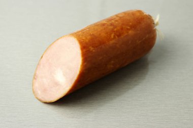 Gri bir masada dilimlenmiş haşlanmış sosis.