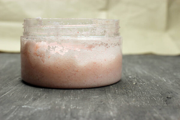 Natural scrub in container on grey background