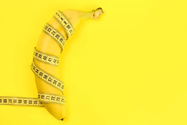 Banane Mit Maßband Auf Gelbem Hintergrund Ein Konzept Für Gewichtsverlust — Stockfoto